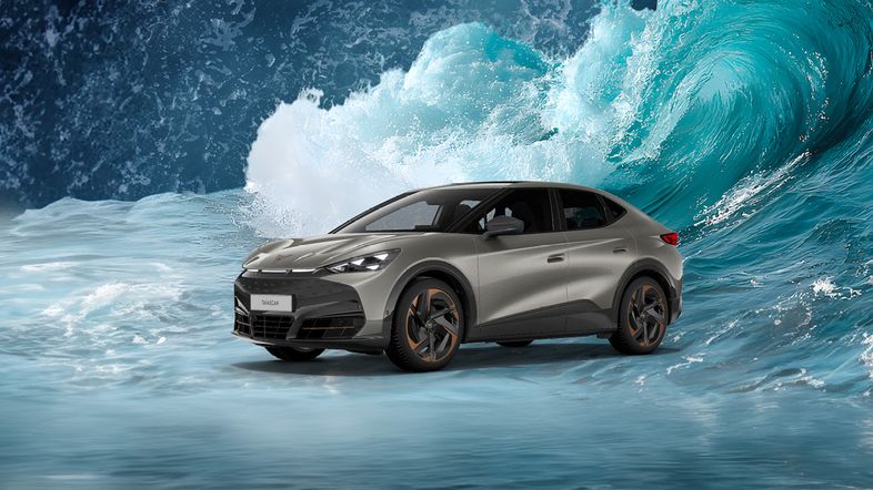 Frontansicht des vollelektrischen Cupra Tavascan in Atacama Desert Metallic mit markanter Lichtsignatur beim Autohaus Ost.