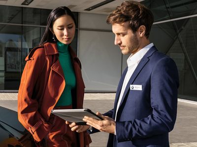Serviceberater für BMW und MINI erklärt der Kundin Wartung an Ihrem Auto