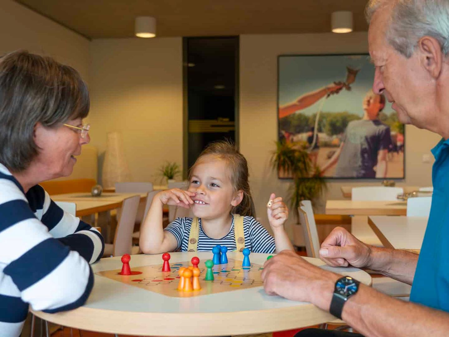 Familie spielt gemeinsam ein Brettspiel in der Lounge des Hotel Haus 54 in Zingst