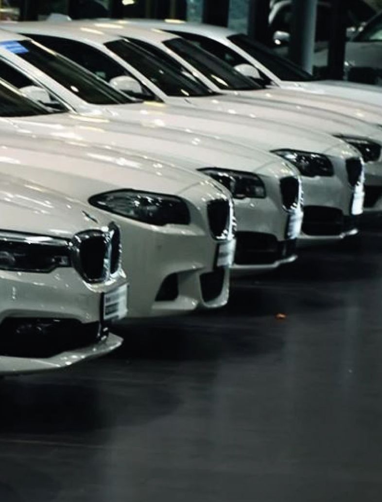 Reihe weißer BMW Gebrauchtwagen im Autohaus – Fahrzeugankauf mit kostenloser Bewertung und fairen Preisen.