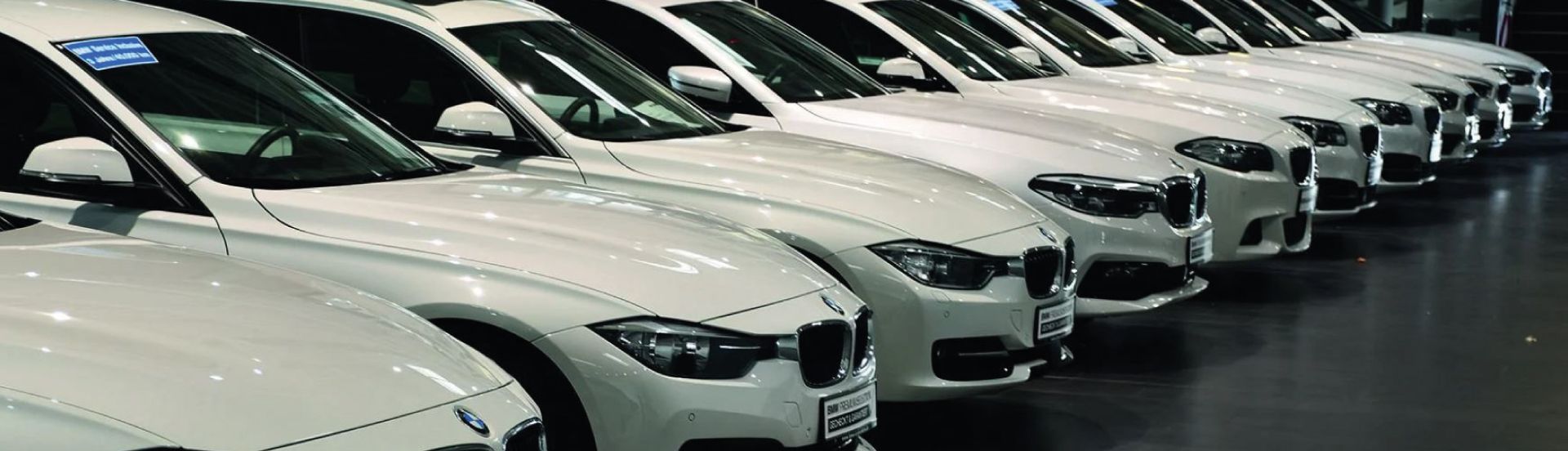 Reihe weißer BMW Gebrauchtwagen im Autohaus – Fahrzeugankauf mit kostenloser Bewertung und fairen Preisen.