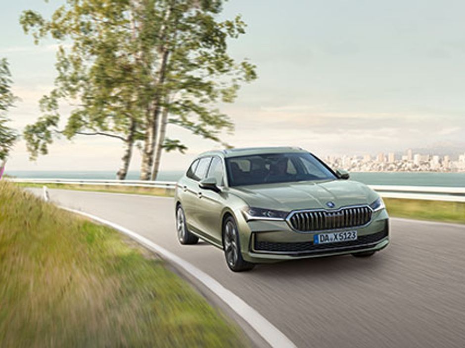 Außenansicht des Skoda Superb Combi Essence Hybrid in Fahrt, zeigt das aerodynamische Design und die moderne Frontpartie.