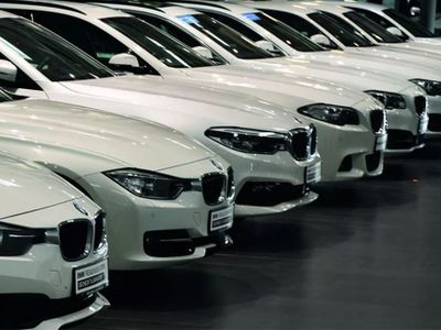 Reihe weißer BMW Gebrauchtwagen im Autohaus – Fahrzeugankauf mit kostenloser Bewertung und fairen Preisen.